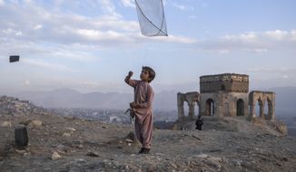 A boy flies a kite on Tape Nadir Khan hill in Kabul, Afghanistan, on Saturday, Dec. 4 , 2021. (AP Photo/Petros Giannakouris)