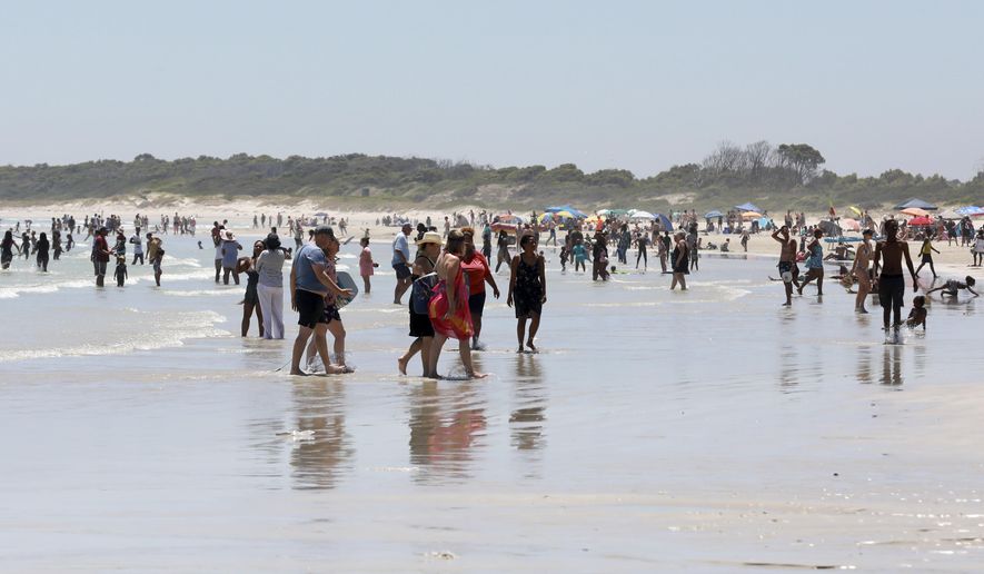 Holdiaymakers enjoy a day at Strand Beach near Cape Town, South Africa, Tuesday, Dec. 21, 2021. South Africa&#39;s drop in new COVID-19 cases in recent days may signal the country&#39;s dramatic omicron-driven surge has passed its peak, medical experts say. (AP Photo/Nardus Engelbrecht)
