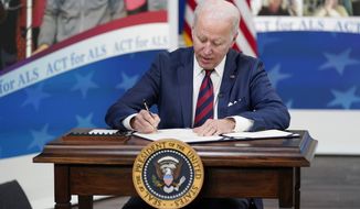 President Joe Biden signs the &quot;Accelerating Access to Critical Therapies for ALS Act&quot; into law during a ceremony in the South Court Auditorium on the White House campus in Washington, Thursday, Dec. 23, 2021. (AP Photo/Patrick Semansky)