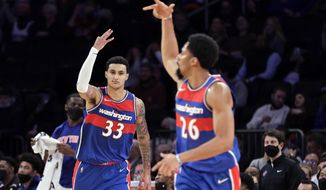 Washington Wizards forward Kyle Kuzma (33) and teammate Spencer Dinwiddie gesture after Kuzma&#39;s 3-pointer during the second half of the team[&#39;s NBA basketball game against the New York Knicks on Thursday, Dec. 23, 2021, in New York. (AP Photo/Adam Hunger)