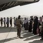 In this image provided by the U.S. Marine Corps, evacuees wait to board a Boeing C-17 Globemaster III during an evacuation at Hamid Karzai International Airport in Kabul, Afghanistan, Monday, Aug. 30. 2021. (Staff Sgt. Victor Mancilla/U.S. Marine Corps via AP, File)   **FILE**