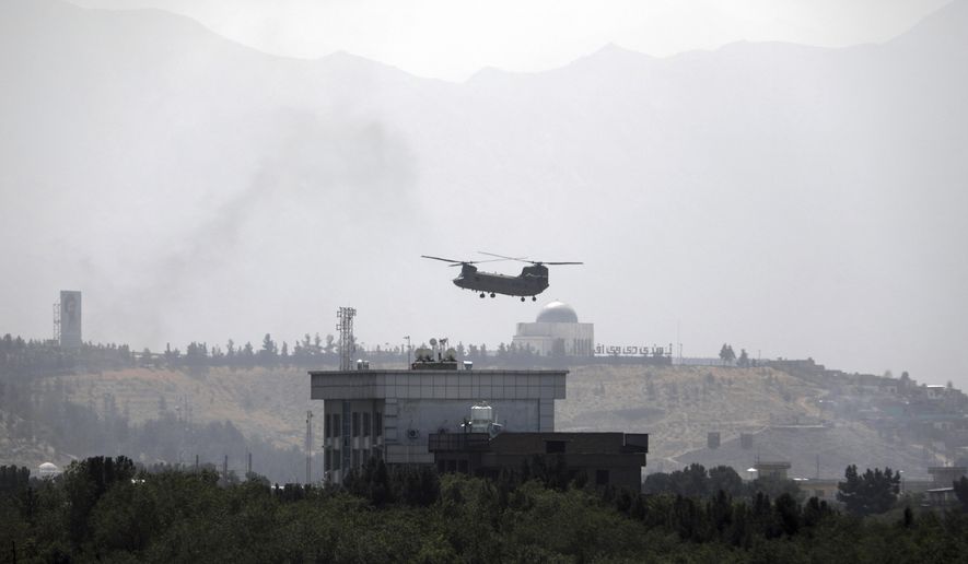 A U.S. Chinook helicopter flies over the U.S. Embassy in Kabul, Afghanistan, Sunday, Aug. 15, 2021. Helicopters landed at the U.S. Embassy in Kabul as diplomatic vehicles left the compound amid the Taliban advance on the Afghan capital. (AP Photo/Rahmat Gul, File)
