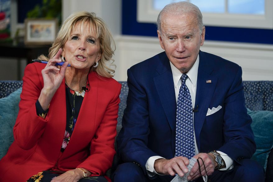 President Joe Biden and first lady Jill Biden speak with the NORAD Tracks Santa Operations Center on Peterson Air Force Base, Colo., and families calling into the NORAD system, via teleconference in the South Court Auditorium on the White House campus in Washington, Friday, Dec. 24, 2021. (AP Photo/Carolyn Kaster)