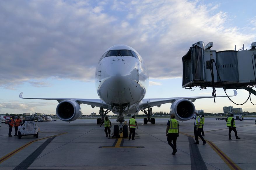 A Lufthansa flight arrives from Munich, Germany, at Miami International Airport, on Nov. 8, 2021, in Miami. Three major airlines have reported canceling dozens of flights as illnesses largely tied to the omicron variant of COVID-19 take a toll on flight crew numbers during the busy holiday travel season. Germany-based Lufthansa said Friday, Dec. 24, 2021, that it was canceling a dozen long-haul transatlantic flights over the Christmas holiday period because of a “massive rise” in sick leave among pilots. (AP Photo/Lynne Sladky) **FILE**