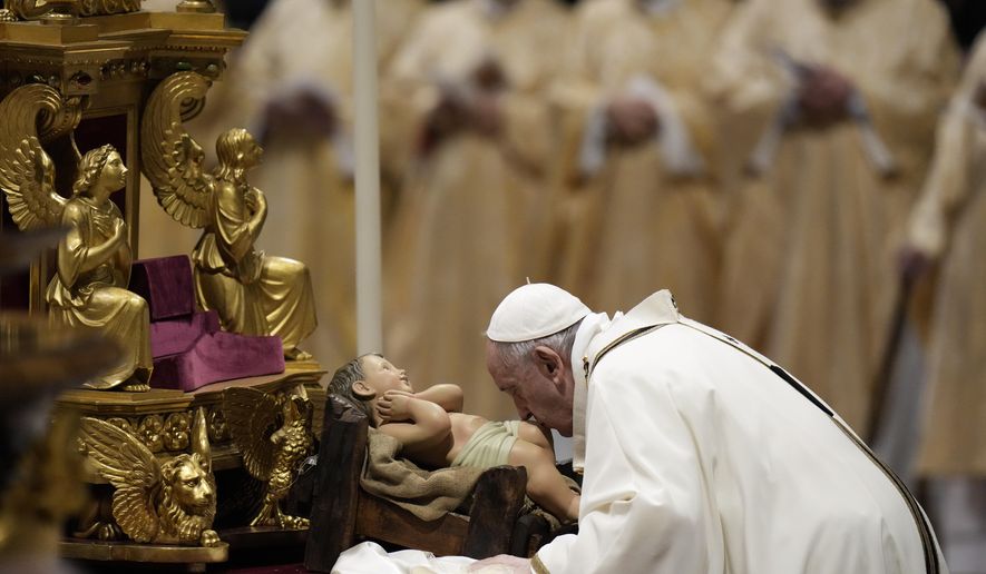 Pope Francis kisses a statue of Baby Jesus as he celebrates Christmas Eve Mass, at St. Peter&#39;s Basilica, at the Vatican, Friday Dec. 24, 2021. Pope Francis is celebrating Christmas Eve Mass before an estimated 1,500 people in St. Peter’s Basilica. He&#39;s going ahead with the service despite the resurgence in COVID-19 cases that has prompted a new vaccine mandate for Vatican employees. (AP Photo/Alessandra Tarantino)