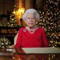 In this undated photo issued on Thursday Dec. 23, 2021, Britain&#39;s Queen Elizabeth II records her annual Christmas broadcast in Windsor Castle, Windsor, England. The photograph at left shows The Queen and Prince Philip taken in 2007 at Broadlands to mark their Diamond wedding anniversary. (Victoria Jones/Pool via AP)