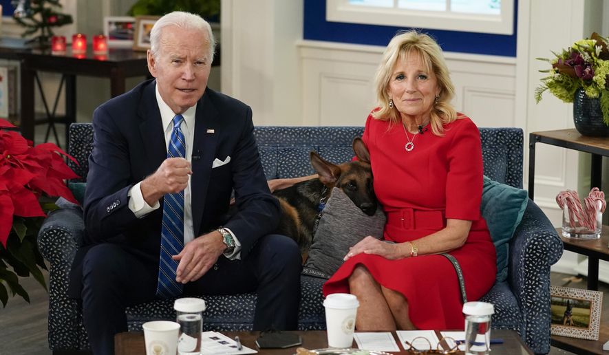 President Joe Biden, first lady Jill Biden and their new dog Commander, a purebred German shepherd puppy, meet virtually with service members around the world, Saturday, Dec. 25, 2021, in the South Court Auditorium on the White House campus in Washington, to thank them for their service and wish them a Merry Christmas. (AP Photo/Carolyn Kaster)