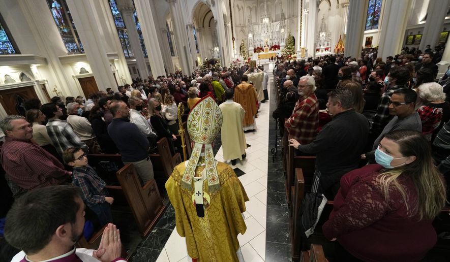 Most Rev. Samuel J. Aquila, archbishop of the archdiocese of Denver, heads down the aisle to conduct Christmas Eve Mass in the Cathedral Basilica of the Immaculate Conception, Friday, Dec. 24, 2021, in downtown Denver. (AP Photo/David Zalubowski)