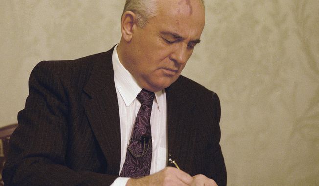 FILE - Mikhail Gorbachev, the final leader of the Soviet Union, signs the decree relinquishing control of nuclear weapons to Boris Yeltsin at the Kremlin in Moscow, Wednesday, Dec. 25, 1991. Gorbachev announced his resignation in a live televised address to the nation on Dec. 25, 1991, drawing a line under more than 74 years of Soviet history. By the fall of 1991, however, deepening economic woes and secessionist bids by Soviet republics had made the collapse of the USSR all but inevitable. The failed August 1991 hardliner coup was a major catalyst, dramatically eroding Gorbachev&#x27;s authority and encouraging more republics to seek independence. (AP Photo/Liu Heung Shing, File)
