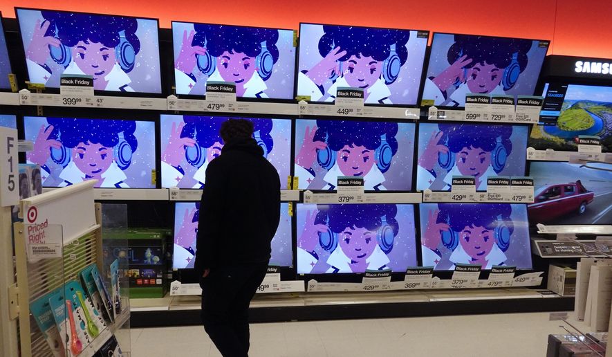 A shopper looks at televisions during a Black Friday sale at a Target, Friday, Nov. 26, 2021, in Indianapolis. Holiday sales rose at the fastest pace in 17 years, even as shoppers grappled with higher prices, product shortages and a raging new COVID-19 variant in the last few weeks of the season, according to one spending measure. (AP Photo/Darron Cummings, File)