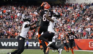 Cincinnati Bengals&#39; Tee Higgins (85) makes a catch against  Baltimore Ravens&#39; Brandon Stephens (21) and Kevon Seymour during the first half of an NFL football game, Sunday, Dec. 26, 2021, in Cincinnati. (AP Photo/Jeff Dean)