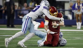 Dallas Cowboys defensive end Tarell Basham, left, and defensive end Dorance Armstrong (92), right, combine to tackle Washington Football Team quarterback Kyle Allen (8) in the second half of an NFL football game in Arlington, Texas, Sunday, Dec. 26, 2021. (AP Photo/Roger Steinman)