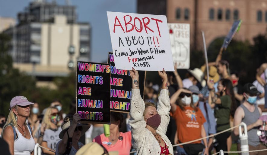 People attend the Women&#39;s March ATX rally, Saturday, Oct., 2, 2021, at the Texas State Capitol in Austin, Texas.  An expected decision by the U.S. Supreme Court in the coming year to severely restrict abortion rights or overturn Roe v. Wade entirely is setting off a renewed round of abortion battles in state legislatures. (AP Photo/Stephen Spillman, File)