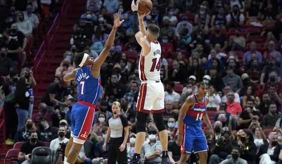 Miami Heat guard Tyler Herro (14) shoots as Washington Wizards guard Jordan Goodwin (9) defends during the first half of an NBA basketball game, Tuesday, Dec. 28, 2021, in Miami. (AP Photo/Lynne Sladky)