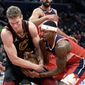 Washington Wizards guard Bradley Beal, right, battles for the ball against Cleveland Cavaliers forward Lauri Markkanen, left, during the first half of an NBA basketball game, Thursday, Dec. 30, 2021, in Washington. (AP Photo/Nick Wass)