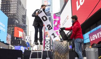 Jonathan Bennett, host of Good Riddance Day, left, and Joe Papa, Director of Events, Times Square Alliance burn a 2021 banner at the official Good Riddance Day celebration in Times Square, Tuesday, Dec. 28, 2021, in New York. (AP Photo/Corey Sipkin)