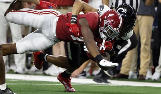 Alabama&#39;s Brian Robinson Jr. (4) is tackled by Cincinnati&#39;s Bryan Cook during the first half of the Cotton Bowl NCAA College Football Playoff semifinal game, Friday, Dec. 31, 2021, in Arlington, Texas. (AP Photo/Michael Ainsworth)