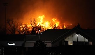 Flames explode as wildfires burned near a small shopping center Thursday, Dec. 30, 2021, near Broomfield, Colo. Homes surrounding the Flatiron Crossing mall were being evacuated as wildfires raced through the grasslands as high winds raked the intermountain West. (AP Photo/David Zalubowski)
