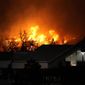 Flames explode as wildfires burned near a small shopping center Thursday, Dec. 30, 2021, near Broomfield, Colo. Homes surrounding the Flatiron Crossing mall were being evacuated as wildfires raced through the grasslands as high winds raked the intermountain West. (AP Photo/David Zalubowski)