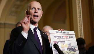 Sen. Rick Scott, R-Fla., holds a printed-out copy the Miami Herald newspaper during a news conference after a weekly Republican policy luncheon on Capitol Hill in Washington, Tuesday, Dec. 7, 2021. (AP Photo/Carolyn Kaster) ** FILE **