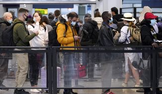 Travelers line up for flights at O&#39;Hare International Airport in Chicago, Thursday, Dec. 30, 2021. (AP Photo/Nam Y. Huh)