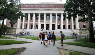 Students walk near the Widener Library at Harvard University in Cambridge, Mass., Aug. 13, 2019. Harvard University is telling students to take classes from home for three weeks, with a return to campus scheduled for late January, &amp;quot;conditions permitting.&amp;quot; (AP Photo/Charles Krupa, File)