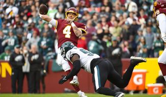 Washington Football Team quarterback Taylor Heinicke (4) throwing the ball while being rushed by Philadelphia Eagles defensive end Milton Williams (93) during the first half of an NFL football game, Sunday, Jan. 2, 2022, in Landover, Md. (AP Photo/Mark Tenally)