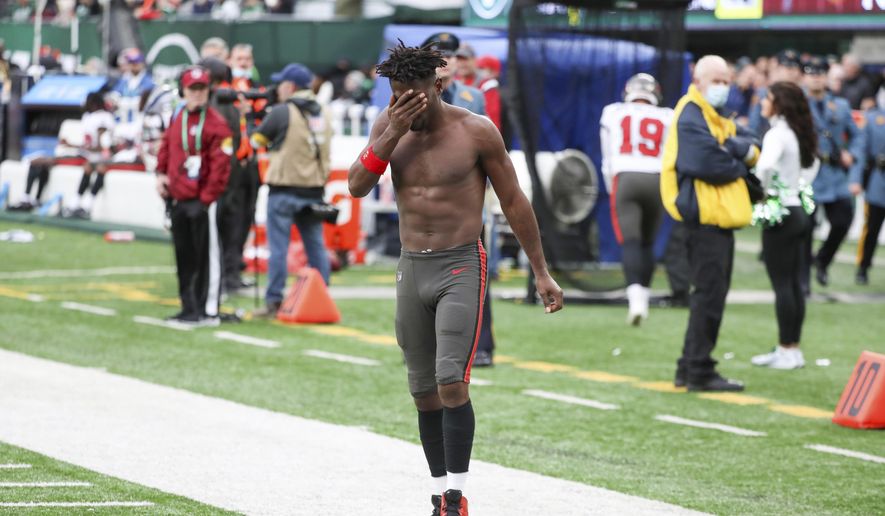 Tampa Bay Buccaneers wide receiver Antonio Brown wipes his face as he leaves the field after throwing his equipment into the stands while his team is on offense during the third quarter of an NFL football game against the New York Jets, Sunday, Jan. 2, 2022, in East Rutherford, N.J. (Andrew Mills/NJ Advance Media via AP) **FILE**