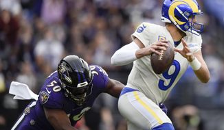 Los Angeles Rams quarterback Matthew Stafford (9) dodges a sack attempt by Baltimore Ravens outside linebacker Justin Houston (50) during the first half of an NFL football game, Sunday, Jan. 2, 2022, in Baltimore. (AP Photo/Gail Burton)