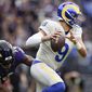 Los Angeles Rams quarterback Matthew Stafford (9) dodges a sack attempt by Baltimore Ravens outside linebacker Justin Houston (50) during the first half of an NFL football game, Sunday, Jan. 2, 2022, in Baltimore. (AP Photo/Gail Burton)