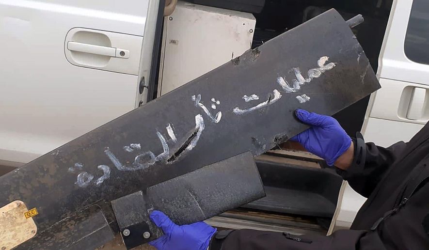 A security official holds part of the wreckage of a drone with Arabic that reads, &amp;quot;revenge operations for our leaders,&amp;quot; at Baghdad airport, Iraq, Monday, Jan. 3, 2022. Two armed drones were shot down at the Baghdad airport on Monday, a U.S.-led coalition official said, an attack that coincides with the anniversary of the 2020 U.S. killing of a top Iranian general.  (International Coalition via AP)