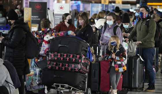 Passengers queue up to check in at the counter for Air Canada Monday, Jan. 3, 2022, in the main terminal of Denver International Airport in Denver. (AP Photo/David Zalubowski) ** FILE **