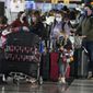 Passengers queue up to check in at the counter for Air Canada Monday, Jan. 3, 2022, in the main terminal of Denver International Airport in Denver. (AP Photo/David Zalubowski) ** FILE **