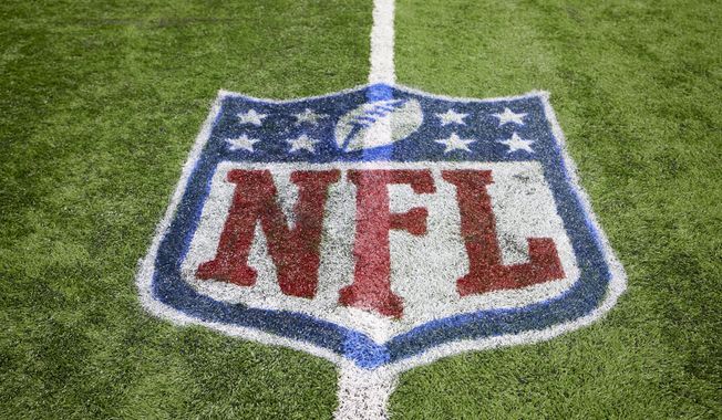 The NFL logo is shown on the field during an NFL football game, Sunday, Dec. 5, 2021, in Detroit. A late-season surge in COVID-19 cases had the NFL in 2021 looking a lot like 2020, when the coronavirus led to significant disruptions, postponements and changing protocols. The emerging omicron variant figures to play a role all the way through the playoffs, including the Super Bowl in Los Angeles, where California has always been aggressive with policies to combat the spread of the virus. (AP Photo/Rick Osentoski, File) ** FILE**