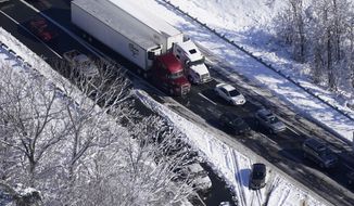 Cars and trucks exit from a section of Interstate 95 Tuesday Jan. 4, 2022, in Stafford, Va. Close to 48 miles of the Interstate was closed due to ice and snow. (AP Photo/Steve Helber)
