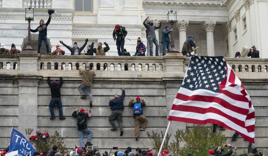 Rioters scale a wall at the U.S. Capitol on Jan. 6, 2021, in Washington. (AP Photo/Jose Luis Magana)  **FILE**