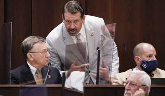 Rep. Jeremy Faison, R-Cosby, center, talks with Rep. Dan Howell, R-Georgetown, left, during a meeting, Aug. 11, 2020, in Nashville, Tenn. A top Tennessee House Republican lawmaker has apologized for losing his temper and being ejected from watching a high school basketball game after getting into a confrontation with a referee, including a brief gesture at pulling down the official&#39;s pants that is visible in video footage of the game. On Tuesday, Jan. 4, 2022 Rep. Jeremy Faison, 45, posted on Twitter that he “acted the fool tonight and lost my temper on a ref.” (AP Photo/Mark Humphrey, file)