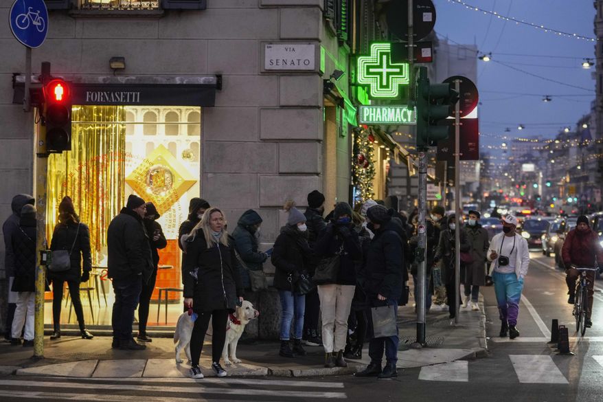 People line up outside a pharmacy for COVID-19 swab tests, in front of Milan's Duomo gothic cathedral, Italy, Dec. 23, 2021. An unprecedented number of coronavirus infections is once again exposing the underfunding and shortcomings of public health care systems, even in developed parts of Europe. (AP Photo/Luca Bruno, File)