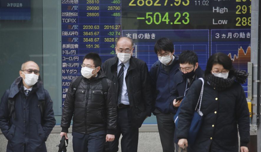 People walk by an electronic stock board of a securities firm in Tokyo, Thursday, Jan. 6, 2022. Asian stock markets followed Wall Street lower on Thursday after investors saw minutes from a Federal Reserve meeting as a sign the U.S. central bank might hike interest rates faster to cool inflation. (AP Photo/Koji Sasahara)