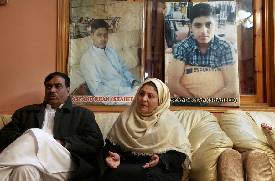 Pakistani mother Shahana with her husband Ajoon Khan sit next to photos of their son Asfand Khan, who was killed in a 2014 assault by Pakistani Taliban militants on an army public school, during an interview with The Associated Press, in Peshawar, Pakistan, Wednesday, Dec. 29, 2021. Each year on Jan. 17 Shahana bakes a cake and invites friends to her home to sing happy birthday, even light a candle but it&#39;s a birthday without the birthday boy, she says. (AP Photo/Muhammad Sajjad)