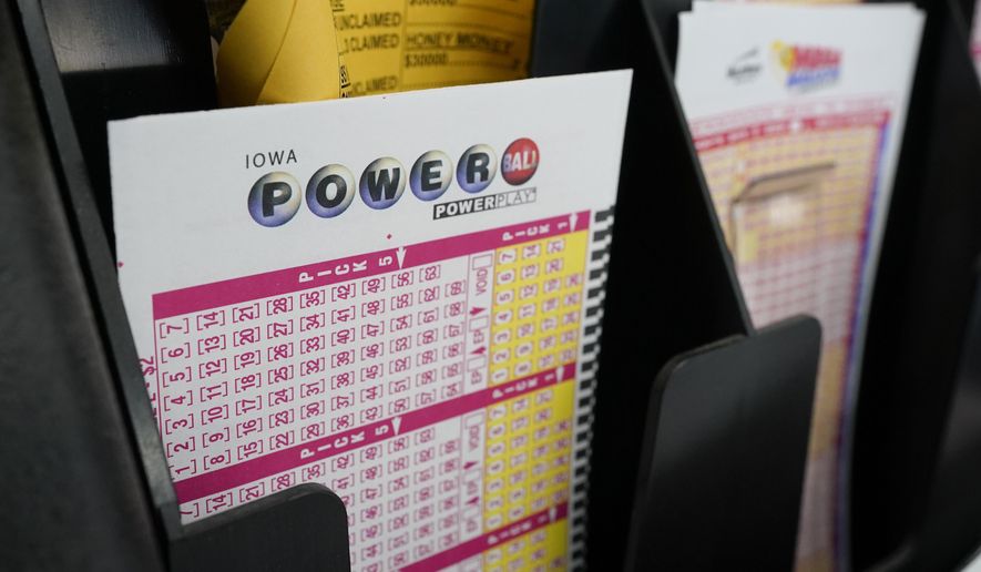 In this Jan. 12, 2021 file photo, blank forms for the Powerball lottery sit in a bin at a local grocery store, in Des Moines, Iowa. (AP Photo/Charlie Neibergall, File)