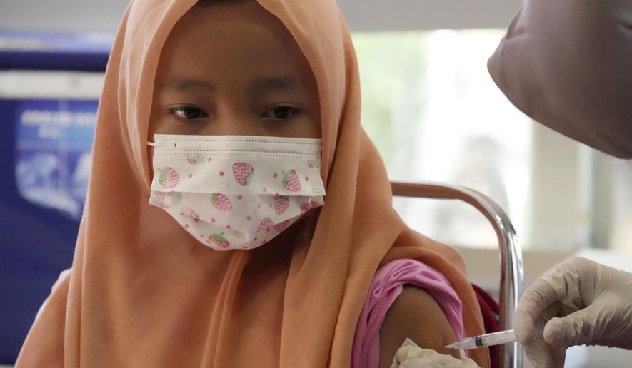 A child receives a shot of the Sinovac COVID-19 vaccine during a vaccination campaign for children aged 6-11 in Tangerang, Indonesia, Thursday, Jan. 6, 2022. (AP Photo/Tatan Syuflana)