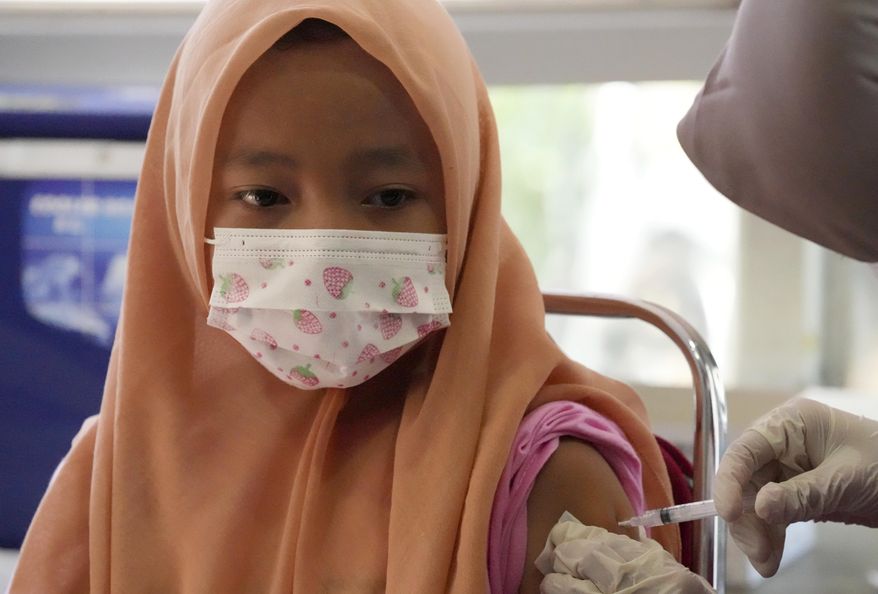 A child receives a shot of the Sinovac COVID-19 vaccine during a vaccination campaign for children aged 6-11 in Tangerang, Indonesia, Thursday, Jan. 6, 2022. (AP Photo/Tatan Syuflana)