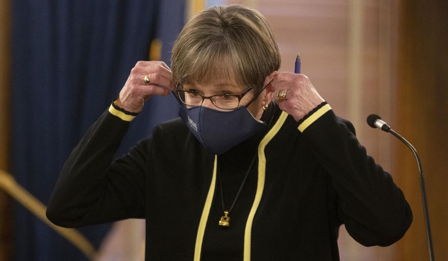 Gov. Laura Kelly puts her face mask back on after taking questions at a press conference at the Statehouse Thursday, Jan. 6, 2022, in Topeka, Kan. Gov. Kelly on Thursday eased or suspended Kansas licensing rules for medical personnel and nursing home workers in hopes of making it easier for them to attack staffing shortages during a surge of new COVID-19 cases. (Evert Nelson/The Topeka Capital-Journal via AP)