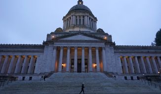 A jogger runs past the Legislative Building just before dusk on Dec. 21, 2021, at the Capitol in Olympia, Wash. (AP Photo/Ted S. Warren, File)