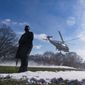 A U.S. Secret Service Special Agent stands as Marine One, with President Joe Biden aboard, lifts off from the South Lawn of the White House blowing snow with the rotor wash, Friday, Jan. 7, 2022, in Washington. Biden is en route to Colorado and Las Vegas. (AP Photo/Alex Brandon)