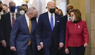 FILE - President Joe Biden is flanked by Senate Majority Leader Chuck Schumer of N.Y., left, and House Speaker Nancy Pelosi of Calif., right, after arriving on Capitol Hill in Washington, Thursday, Jan. 6, 2022, to speak at a ceremony marking the one year anniversary of the Jan. 6 attack on the Capitol by supporters loyal to then-President Donald Trump. Biden will deliver his first State of the Union address on March 1, the White House confirmed Friday, Jan. 7, after Pelosi sent the president a formal invitation to speak to Congress and the American public one year into his term. (AP Photo/Susan Walsh, File)