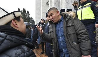 Protesters talk to each other as they gather in support of Kazakh opposition and against deploying Kyrgyzstan&#39;s troops to Kazakhstan during a rally in Bishkek, Kyrgyzstan, Friday, Jan. 7, 2022. The Collective Security Treaty Organization, which includes the former Soviet republics of Kazakhstan, Belarus, Armenia, Tajikistan and Kyrgyzstan have started deploying troops to Kazakhstan for a peacekeeping mission after the worst street protests since the country gained independence three decades ago. The demonstrations began over a near-doubling of prices for a type of vehicle fuel and quickly spread across the country, reflecting wider discontent over the rule of the same party since independence. (AP Photo/Vladimir Voronin)