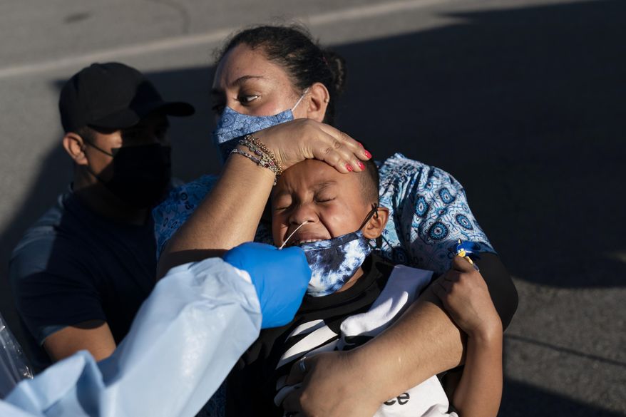 Reina Monterrosa holds the head of her 6-year-old son, Anderson, as nurse practitioner Rita Ray collects a nasal swab sample for a COVID-19 test at Families Together of Orange County community health center in Tustin, Calif., Thursday, Jan. 6, 2022. (AP Photo/Jae C. Hong) **FILE**