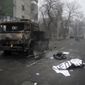 A body of victim covered by a banner, right, lays near to a military truck, which was burned after clashes, in Almaty, Kazakhstan, Thursday, Jan. 6, 2022. Kazakhstan&#x27;s president authorized security forces on Friday to shoot to kill those participating in unrest, opening the door for a dramatic escalation in a crackdown on anti-government protests that have turned violent. The Central Asian nation this week experienced its worst street protests since gaining independence from the Soviet Union three decades ago, and dozens have been killed in the tumult. (AP Photo/Vladimir Tretyakov/NUR.KZ via AP)